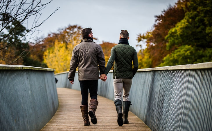 Couple walking through the arboretum in autumn